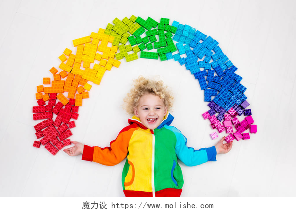 玩七彩积木的男孩小孩在玩彩虹塑料积木